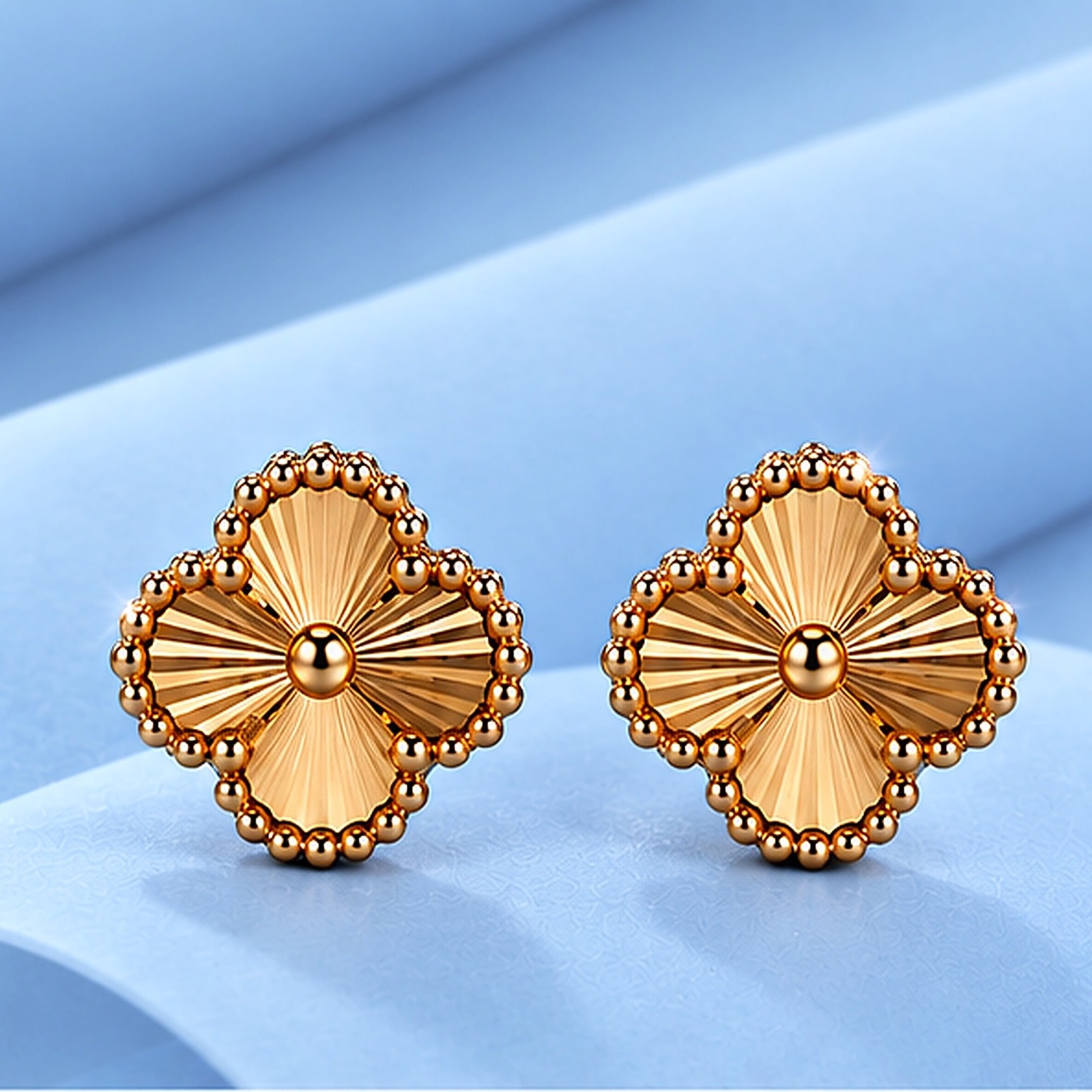 Gold earrings in the style of van cleef