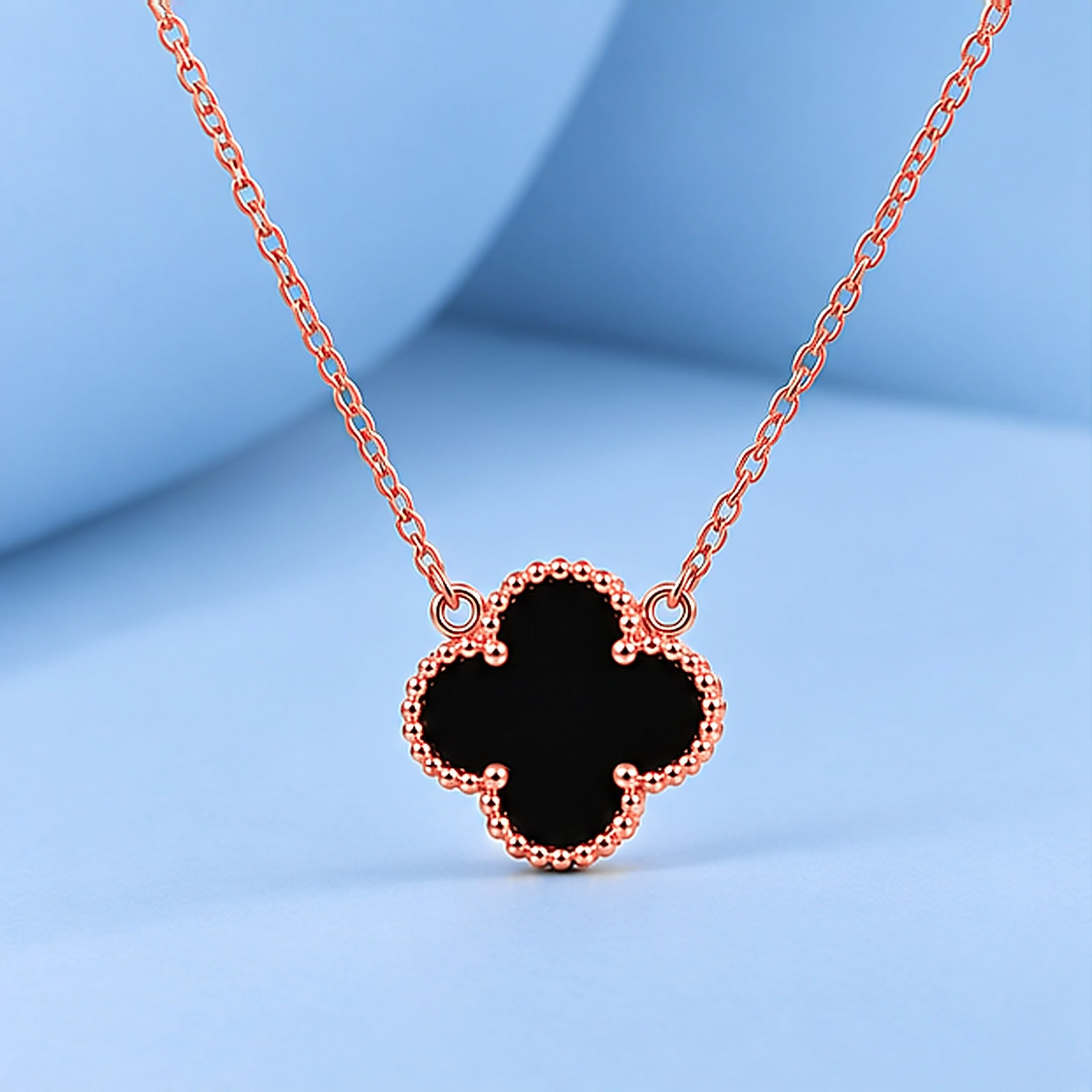 Gold necklace with onyx in the style of van cleef