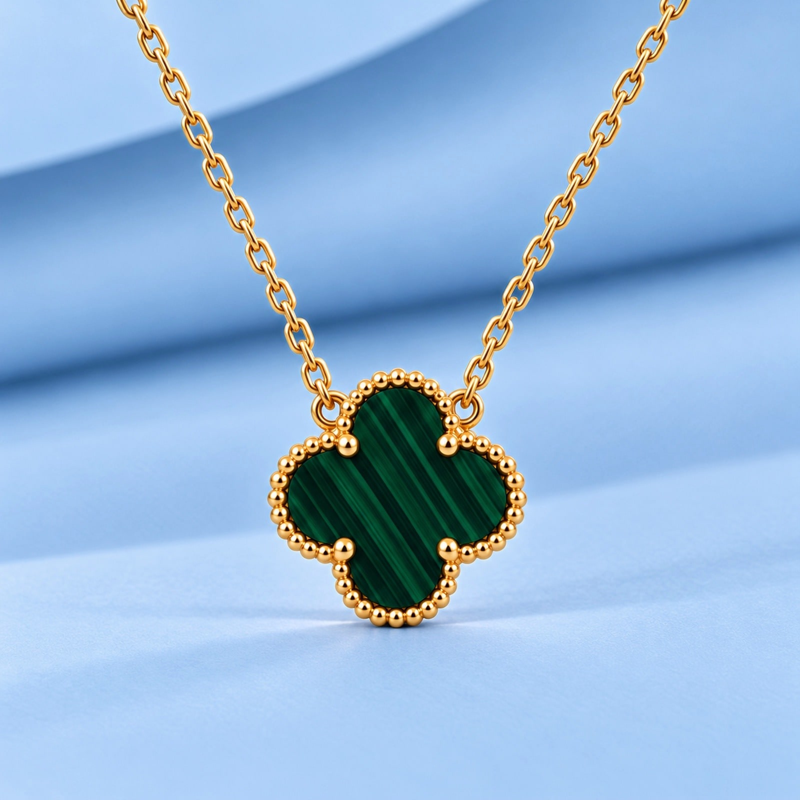 Gold necklace with malachite in the style of van cleef