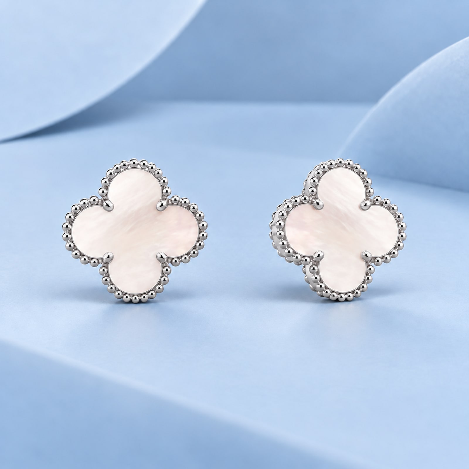 Gold earrings with mother-of-pearl in the style of van cleef