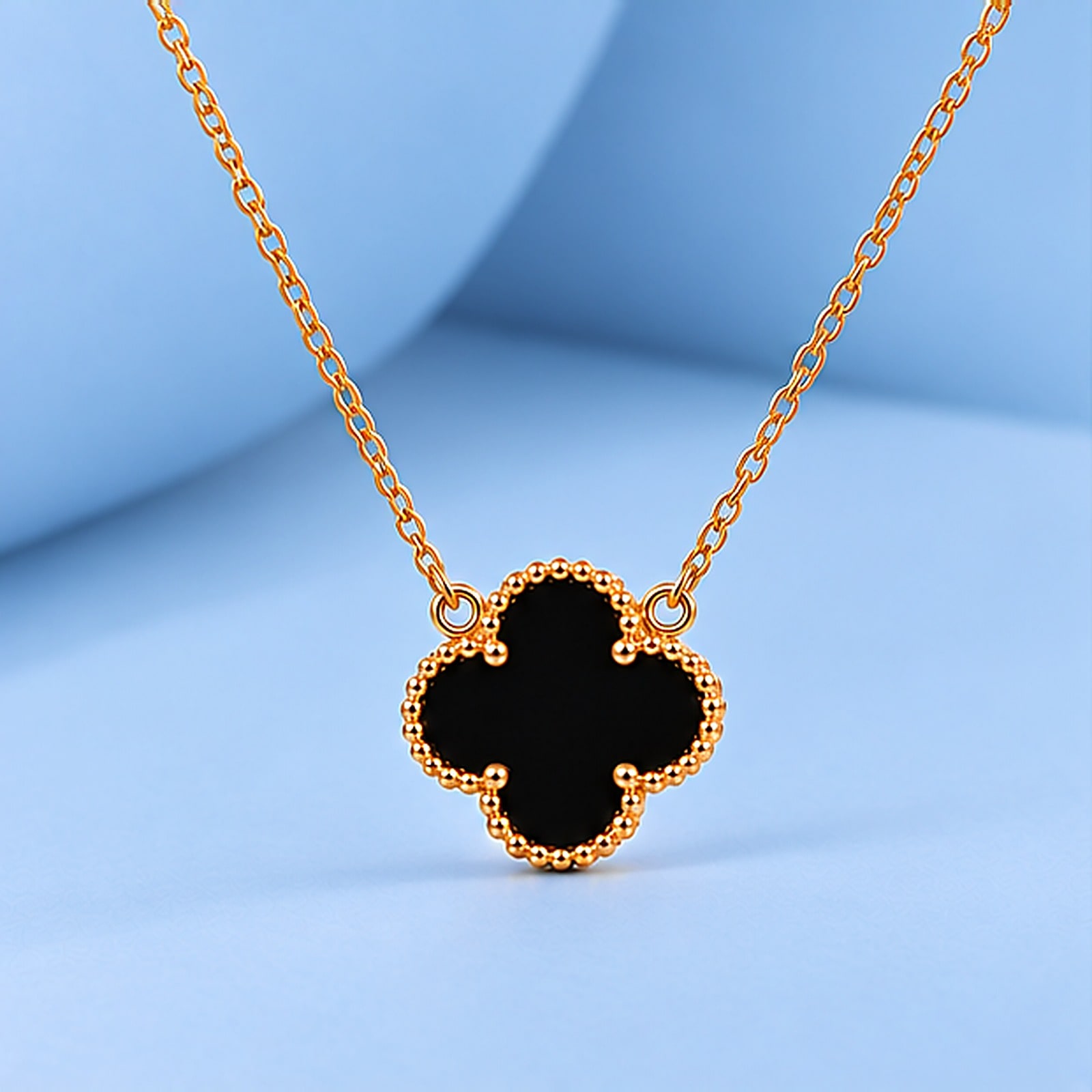 Gold necklace with onyx in the style of van cleef