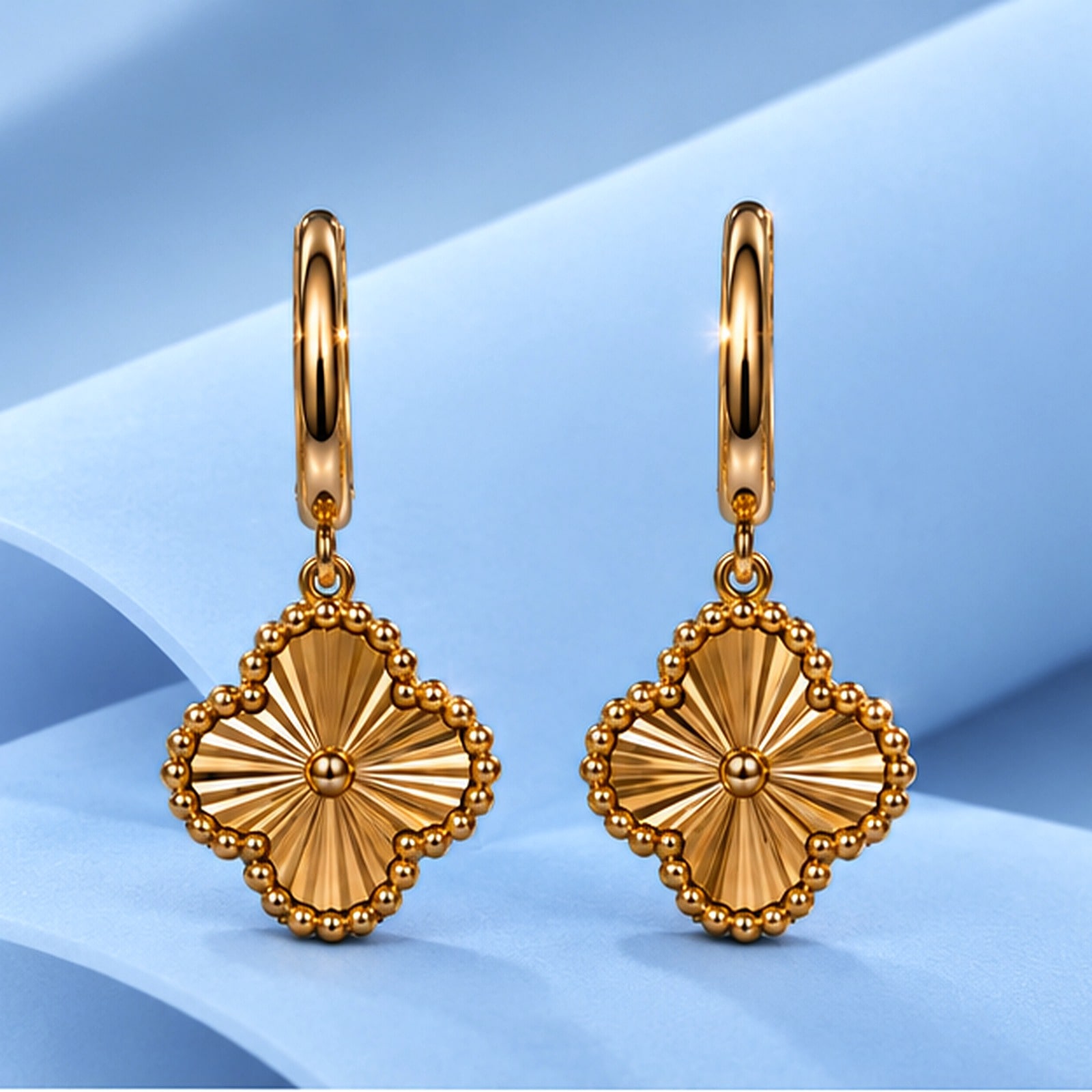 Gold earrings in the style of van cleef