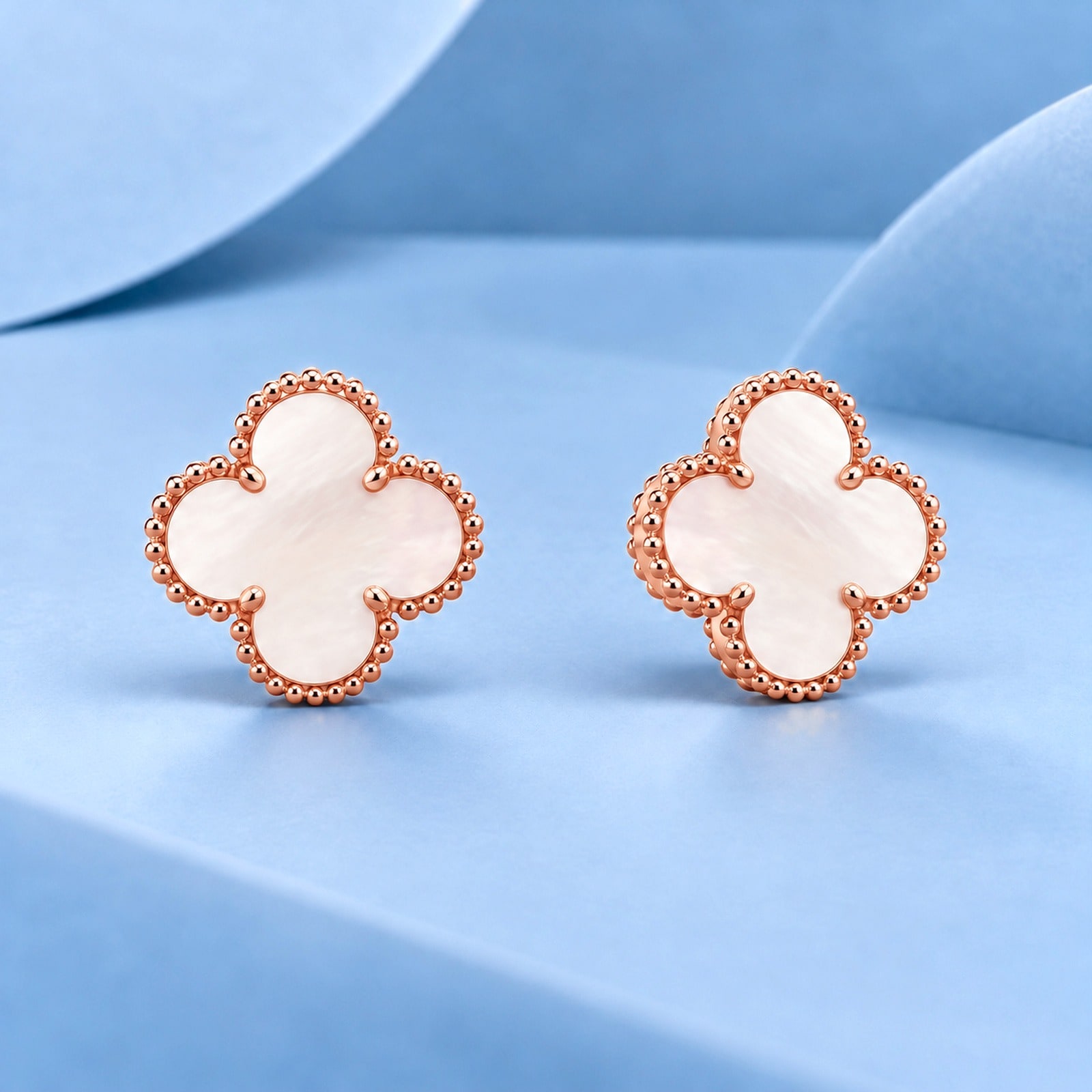 Gold earrings with mother-of-pearl in the style of van cleef