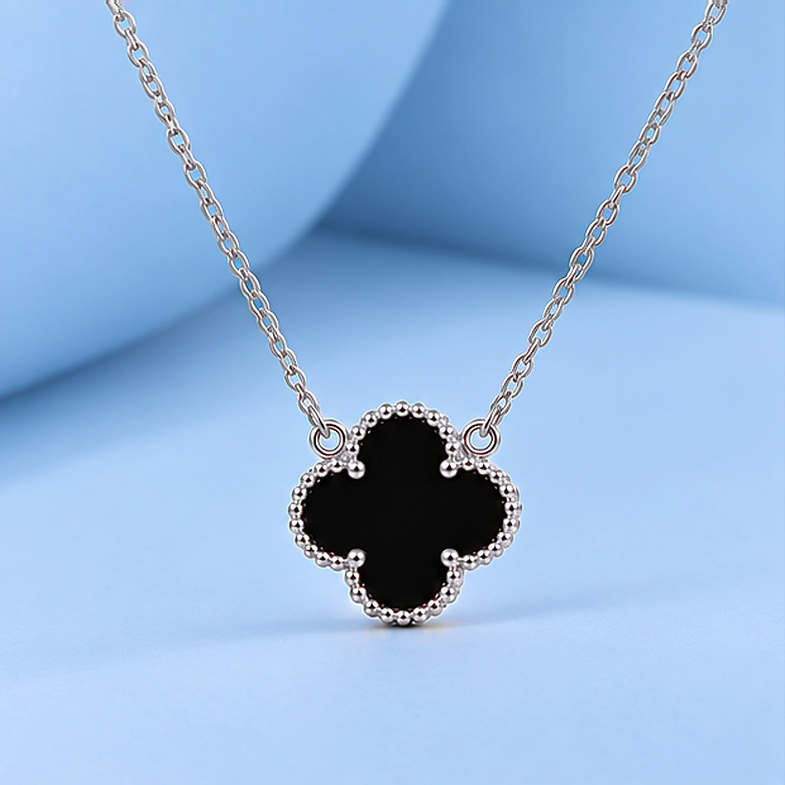 Gold necklace with onyx in the style of van cleef