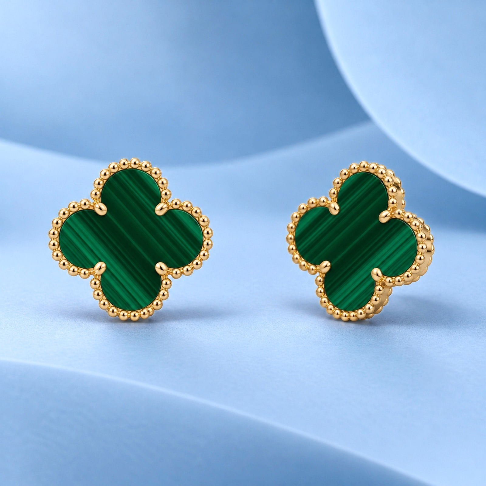 Gold earrings with malachite in the style of van cleef